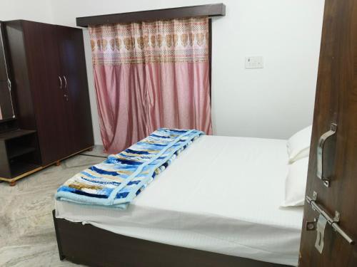 AyodhyaPran Prasadam的窗户客房内的一张白色床