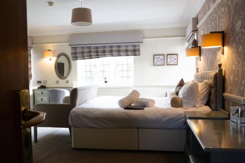 阿什顿下安林恩The Broadoak的卧室设有一张白色大床和一扇窗户。