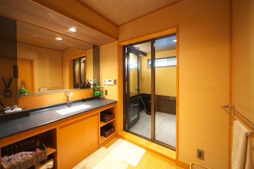 富士河口湖花水庭酒店的一间带水槽和玻璃淋浴的浴室