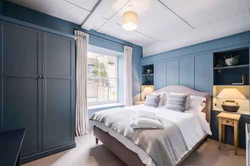 昂德尔Great Escapes Oundle Flat 3的蓝色的卧室设有床和窗户