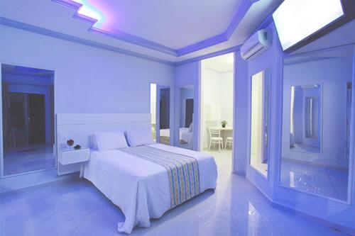 阿拉拉夸拉Motel Haraam的白色的卧室设有白色的床和窗户。