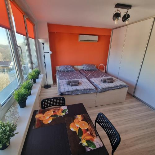 克拉科夫Orange Apartment Kraków的卧室配有一张床和一张桌子及椅子