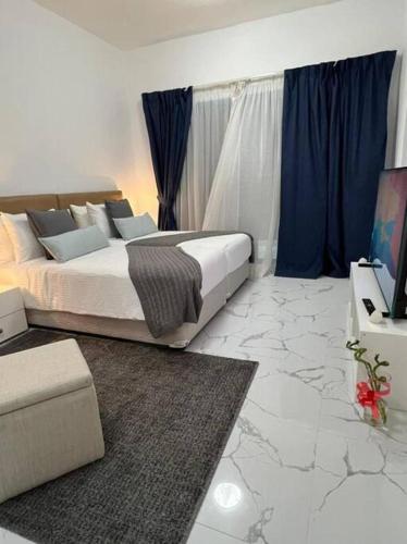 迪拜Private room available in Arjan.的一间卧室配有一张床和一台电视。