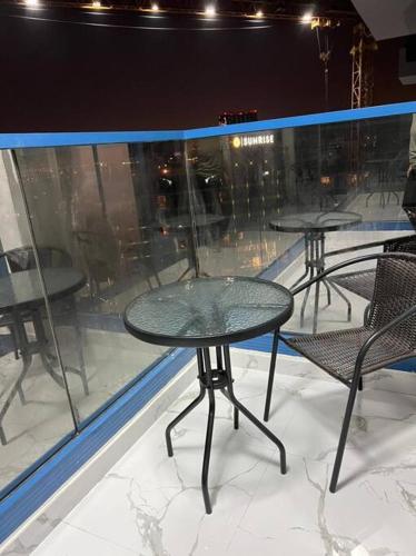 迪拜Private room available in Arjan.的窗前有三把桌子和椅子