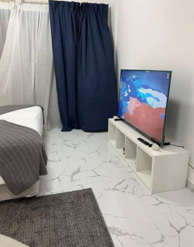 迪拜Private room available in Arjan.的一间客厅,在白色的架子上配有电视