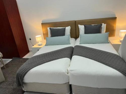 迪拜Private room available in Arjan.的两张位于酒店客房的床,配有两个枕头