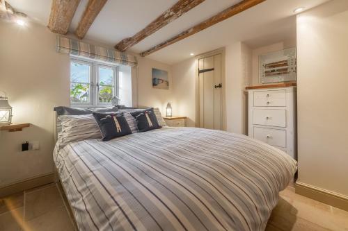 布兰克斯特Mayes Cottage的一间卧室设有一张床和一个窗口