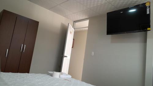 查查波亚斯HOSTAL IMPERIO KALLPA的客房设有一张壁挂式平面电视的床。