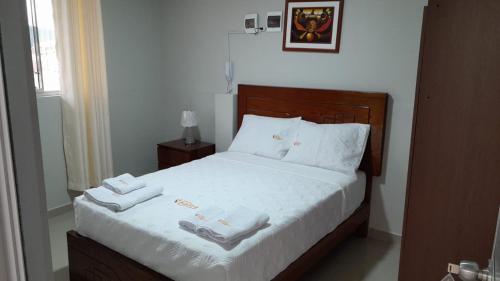 查查波亚斯HOSTAL IMPERIO KALLPA的一间卧室配有一张床,上面有两条毛巾