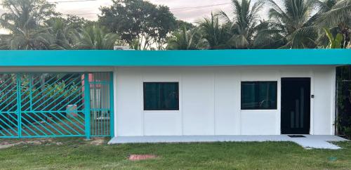 卡维塔Cahuita Apartment by Angie的蓝色屋顶的白色小房子