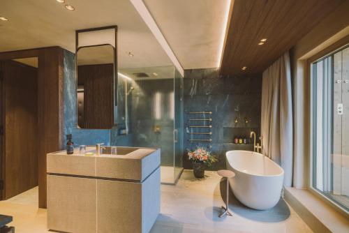 巴特塔茨曼斯多夫Adults Only Hotel Reiters Supreme的一间带大浴缸和水槽的浴室