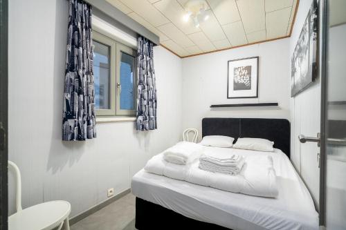 维斯桃特爱丽丝度假屋的一间卧室配有一张带白色床单和蓝色窗帘的床。