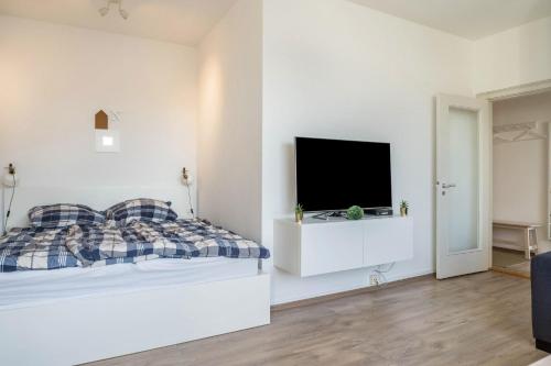 基尔Ferienwohnung Kieler Altstadt的白色卧室配有床和平面电视