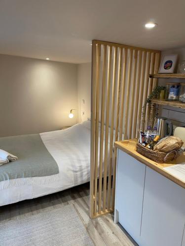 IfordEl Nido - Self Catering cabin in Southbourne, 5 mins from beach的一间卧室设有一张床和一个木制隔板