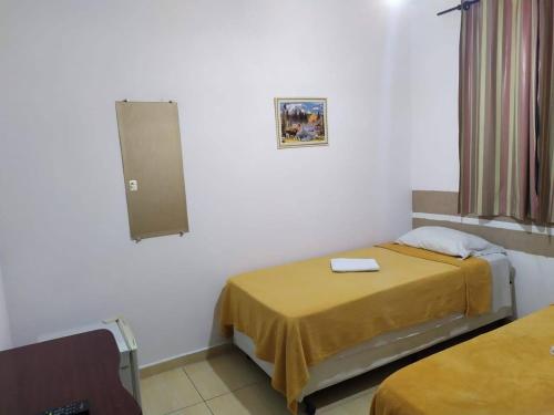 圣保罗豪斯佩达利亚伊皮兰加旅馆的小房间设有两张床和窗户