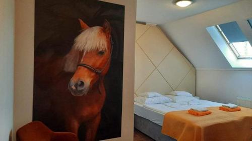 尼赖吉哈佐卡巴鲁斯洛瓦斯马约尔住宿加早餐旅馆的一张床边的马画