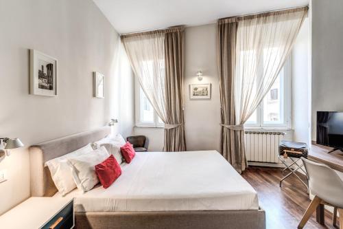 罗马瑞莱小女皇旅馆的一间卧室配有一张带红色枕头的床