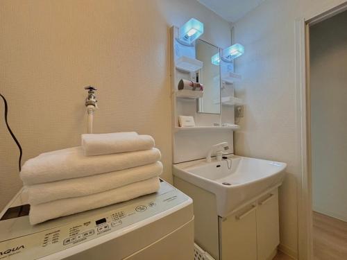 广岛Neighbor's Hotel 十日市的浴室设有水槽和一堆毛巾