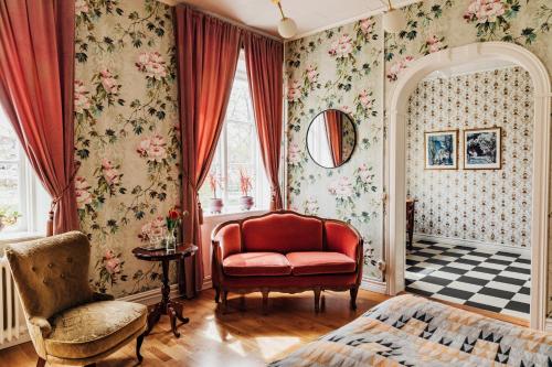 韦斯特维克帕克酒店的客厅配有红色椅子和花卉壁纸