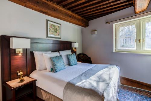 里昂佛罗伦萨别墅酒店的一间卧室设有一张大床和一个窗户。