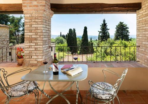 卡斯特利纳-因基安蒂Castello di Fonterutoli Wine Resort的阳台上的桌子和两杯葡萄酒