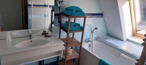 Liessies修道院住宿加早餐旅馆的浴室配有水槽、淋浴和浴缸。