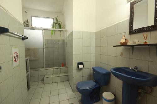 瓜亚基尔Pachamac House的浴室设有蓝色的卫生间和水槽。