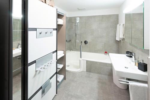 埃申茨Exklusive 2,5 Zimmer Wohnung的一间带水槽、浴缸和卫生间的浴室