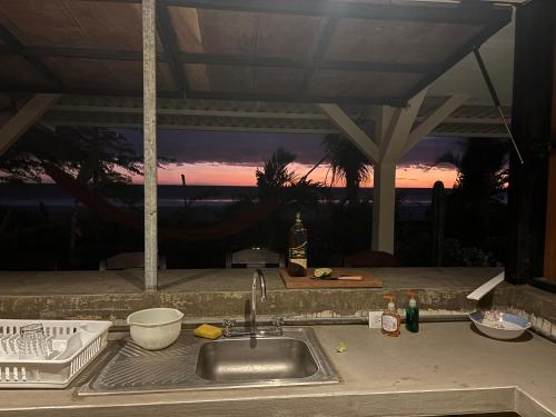 波波约Stella Mar Oceanfront Hotel的厨房水槽,背面有日落
