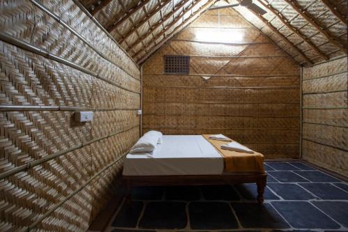 亨比Hampi Social Resort的小房间,木墙里设有一张床