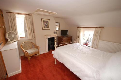 谢林汉姆Romany Rye的卧室配有白色的床和椅子