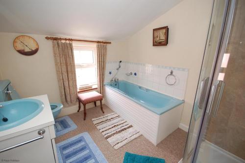 谢林汉姆Romany Rye的浴室配有蓝色浴缸和水槽