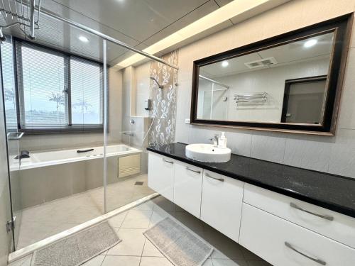 罗东镇罗东公园Villa民宿的一间带水槽、淋浴和镜子的浴室