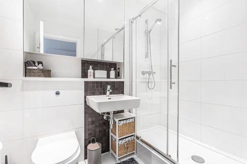赫默尔亨普斯特德High Spec 2 Bed, 2 Bath, Wi-Fi, Balcony的白色的浴室设有水槽和淋浴。
