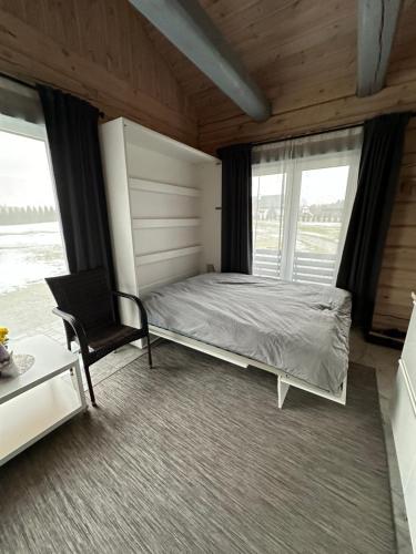 DuķuriDūjas的一间卧室配有一张床、一把椅子和窗户。