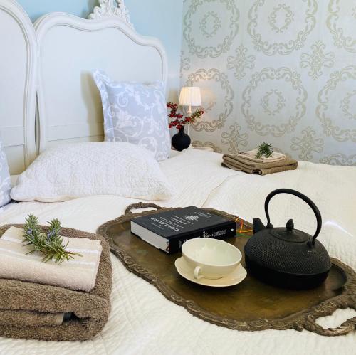 蒙托鲁B&B Charming room with view的床上的茶壶和书籍托盘