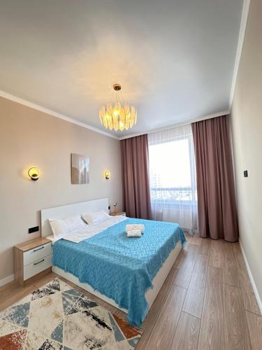 塔尔迪科尔Уютный уголок в центре города Grand Turan的一间卧室配有一张床和一个吊灯