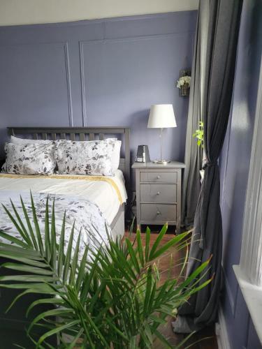 布鲁克林Brooklyn Flat Tropical Vibe的一间卧室配有床、床头柜和植物
