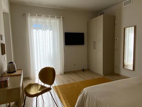 阿尔巴Alba Room 16的一间卧室配有一张床、一把椅子和电视