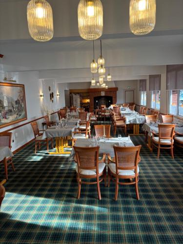 普瓦红衣主教餐厅酒店的用餐室配有桌椅和吊灯。