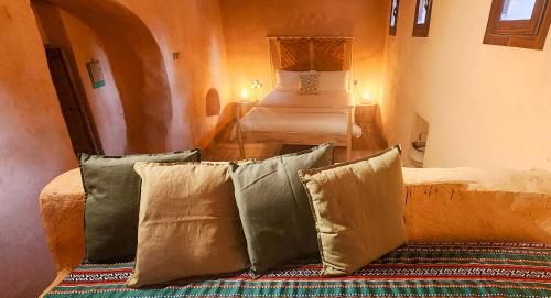 阿尔哈姆拉Bait Al Aali Guesthouse的客房配有床和一些枕头。