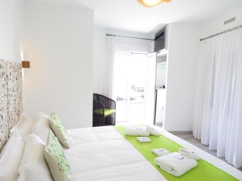 El Pinar del HierroLua Hotel Boutique的白色卧室设有一张绿地毯的大床