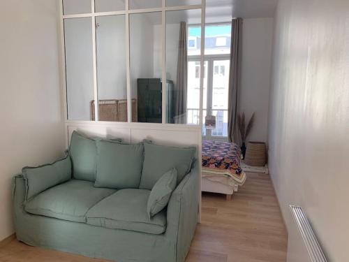 里尔Appartement centre ville avec terrasse的客厅配有绿色沙发和镜子