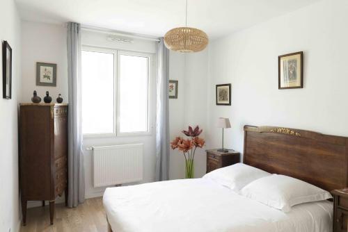 波尔多Queyries - Appartement 2 chambres avec Parking的卧室配有白色的床和窗户。