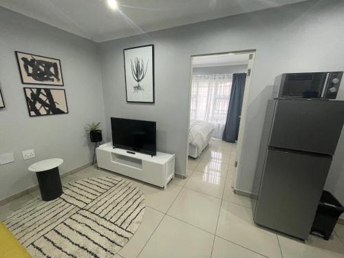 乌姆塔塔Trendy, Comfortable 1 bedroom Apartments in Mthatha的客厅设有壁挂式平面电视。