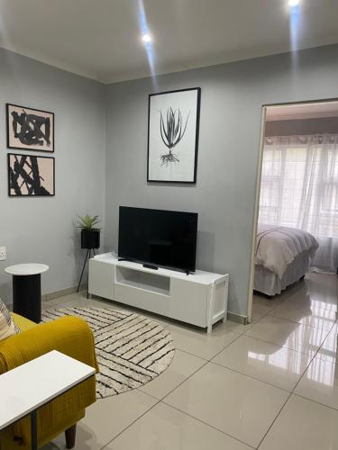 乌姆塔塔Trendy, Comfortable 1 bedroom Apartments in Mthatha的一间客厅,在白色的墙上配有电视