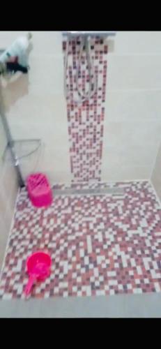 InezganeAppartement moyen standing的浴室铺有瓷砖地板,配有2个粉红色拖鞋。