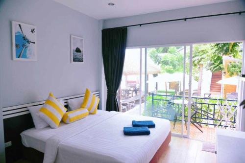 沙美岛Samed Seaside Resort - เสม็ด ซีไซด์ รีสอร์ท的一间卧室配有黄色和蓝色枕头的床