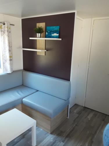 乌伊斯特勒昂Riva Bella chez Caraphou的客厅配有蓝色的沙发和桌子