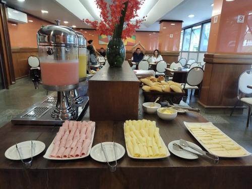 贝洛奥里藏特Hotel Oscar Gold Savassi的一张桌子,上面放有奶酪盘和搅拌机